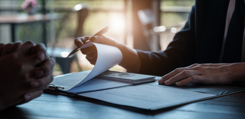 Insurance Disputes A hand flipping through an insurance denial letter, symbolizing insurance dispute cases.